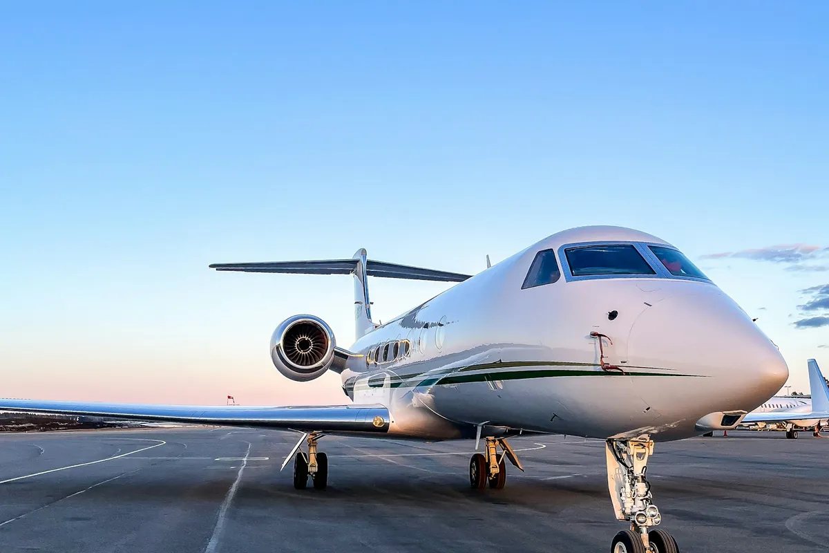 White business jet on the ramp under a clear sky